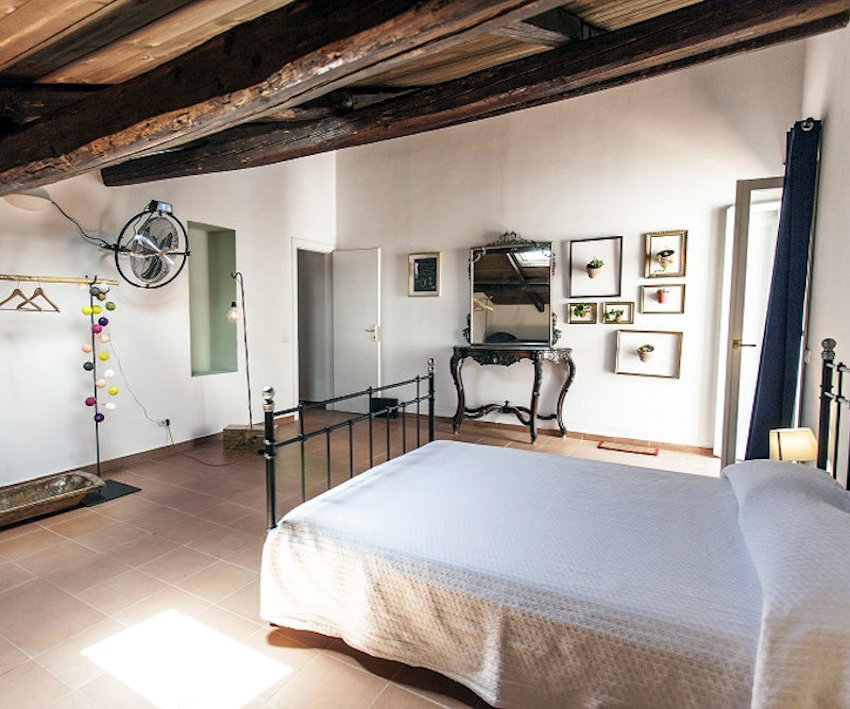 Superior room — bedroom with iron bed, baroque mirror and gold-framed succulents at The Church B&B Naples